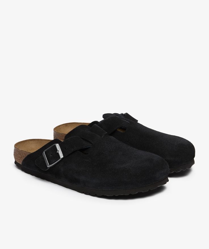 Black suede clogs with cork insoles on a white background