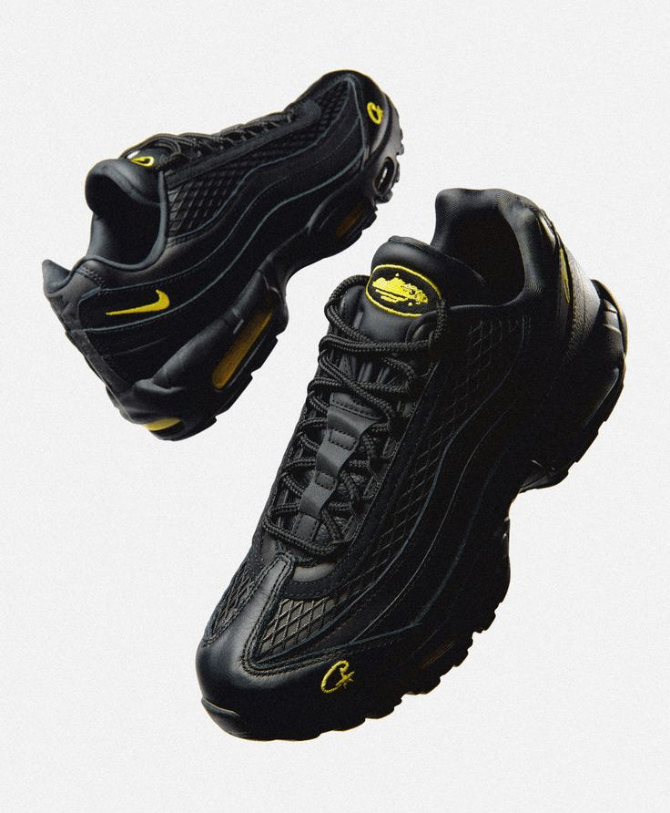 Black sneakers with yellow accents on a light gray background
