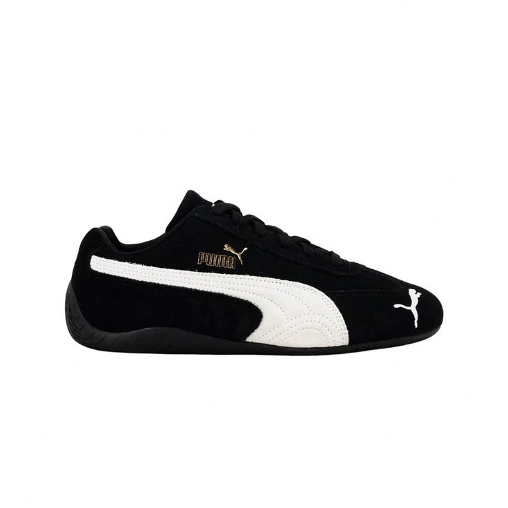A black Puma Suede sneaker with a white side stripe, white Puma cat logo on the toe, and a gold Puma wordmark on the side, shown against a plain white background.