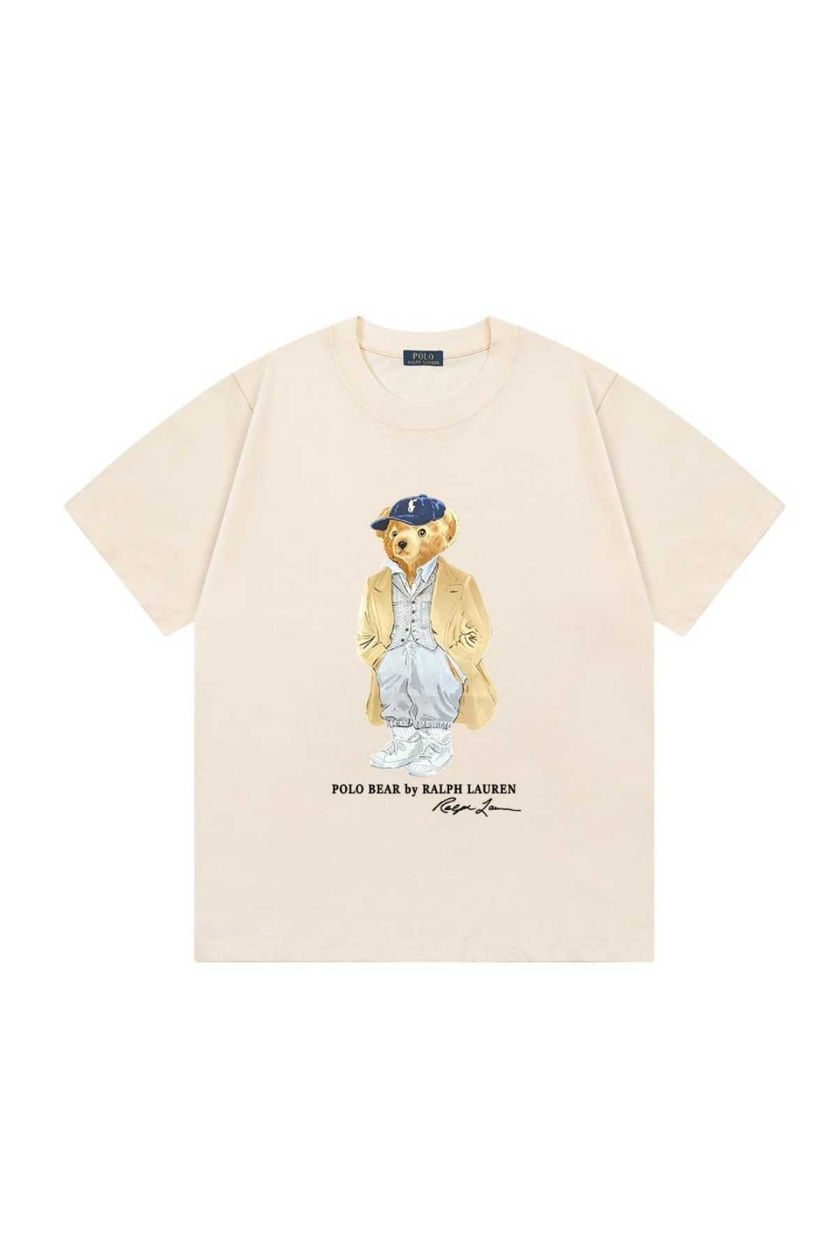 A cream-colored short-sleeve t-shirt featuring a central graphic of the iconic Polo Bear wearing a blue cap and tan jacket, with 'POLO BEAR by RALPH LAUREN' and a signature printed below.
