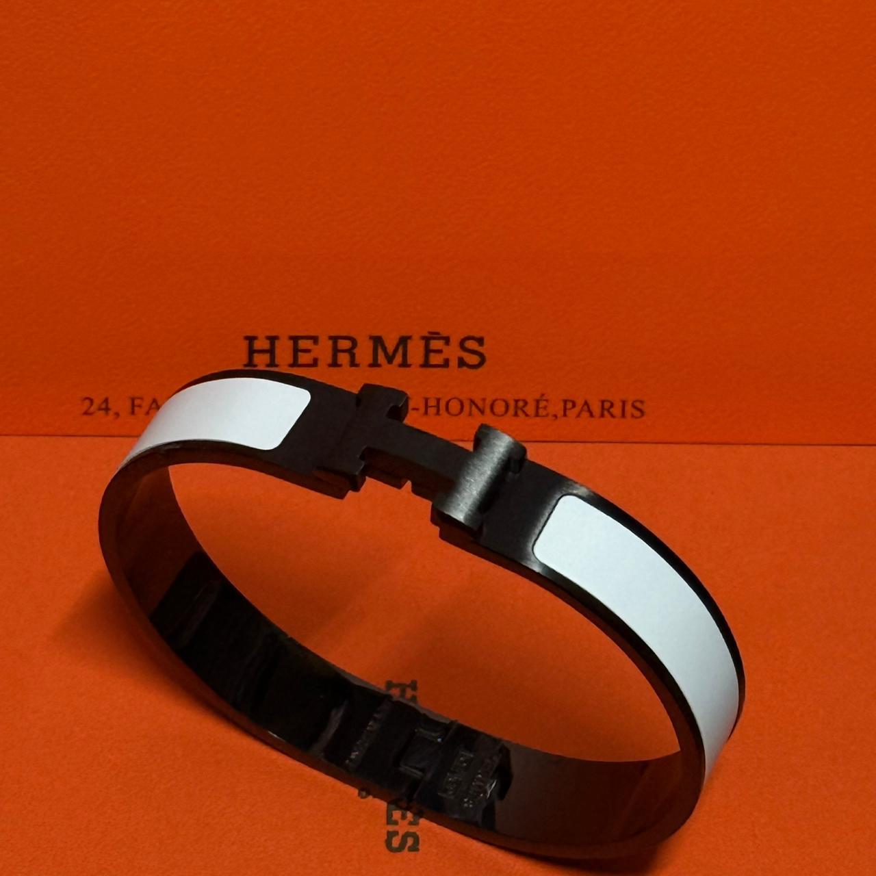 Hermès bracelet on an orange background with brand name visible