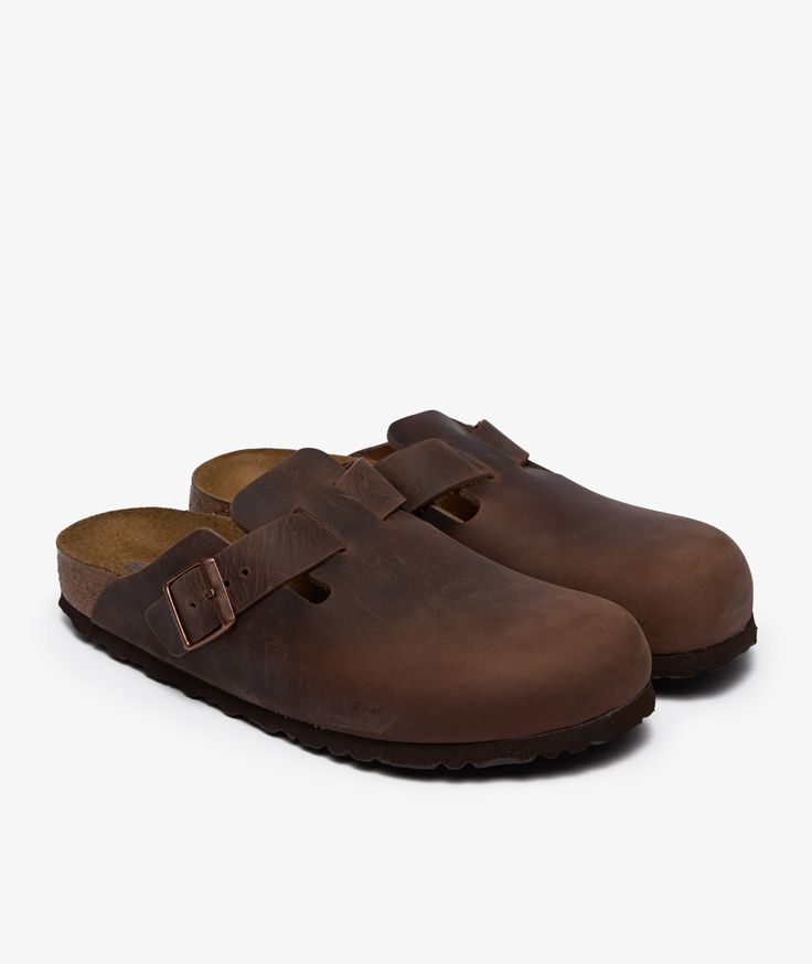 Pair of brown leather clogs on a white background