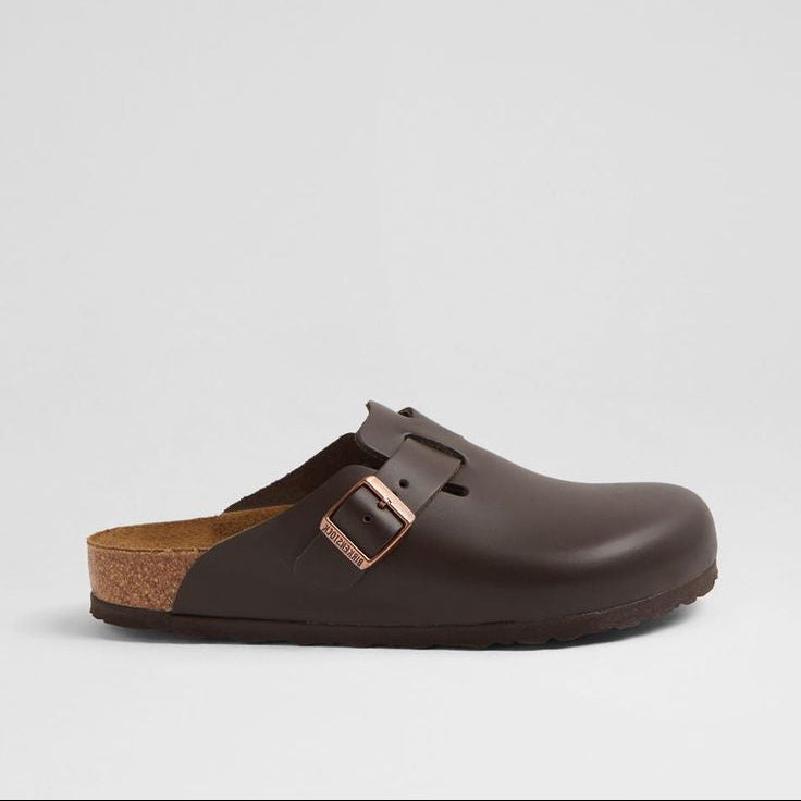 Brown clog shoe with cork sole on a light gray background