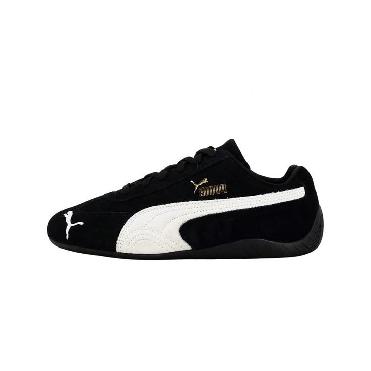 A black Puma Suede sneaker with a white side stripe, white Puma cat logo on the toe, and a gold Puma wordmark on the side, shown against a plain white background.