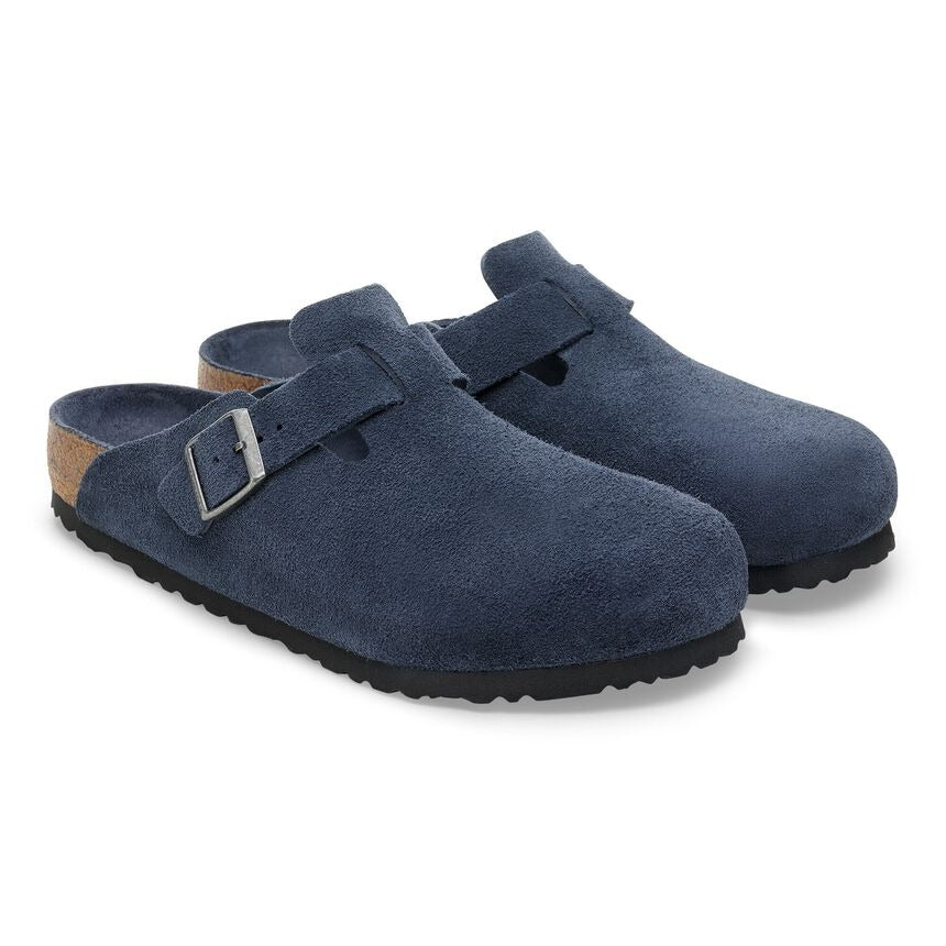 Pair of blue suede clogs on a white background