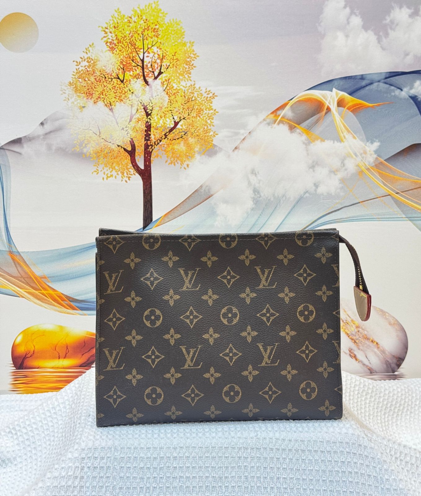Louis Vuitton pouch with monogram pattern against a colorful abstract background